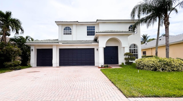 mediterranean / spanish home with a garage and a front yard