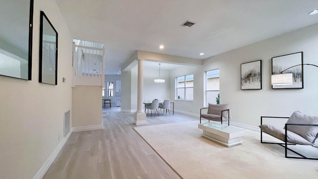 hall featuring a healthy amount of sunlight and light hardwood / wood-style floors