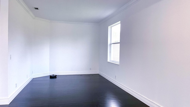 empty room featuring dark wood-type flooring and ornamental molding