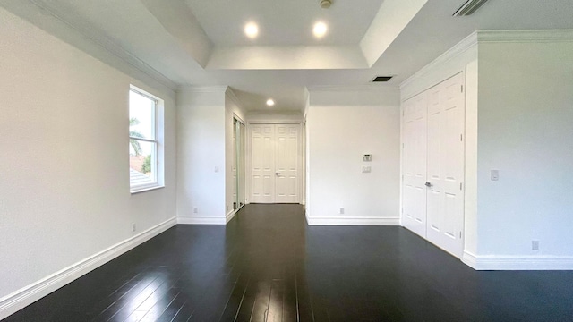 unfurnished room featuring dark hardwood / wood-style flooring, a tray ceiling, and ornamental molding