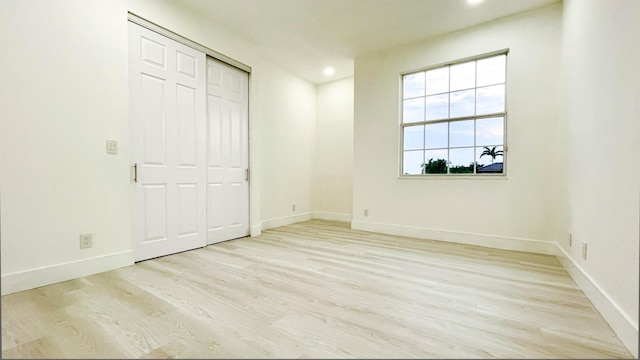 unfurnished bedroom featuring light hardwood / wood-style floors and a closet