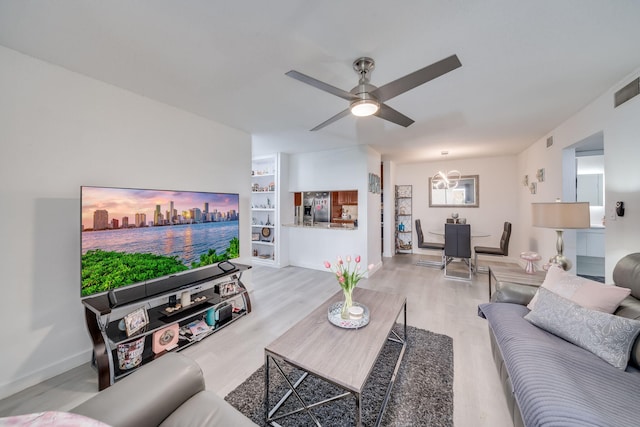 living area with baseboards, visible vents, a ceiling fan, and wood finished floors