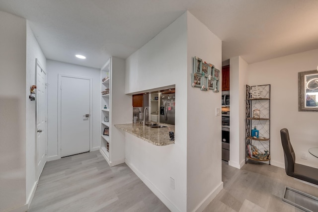927 Riverside Dr Unit 313, Coral Springs, FL 33071 - hallway featuring light wood-type flooring, a sink, baseboards, and built in shelves