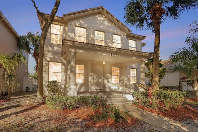 mediterranean / spanish house featuring covered porch