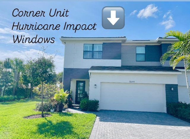 view of front facade with a front lawn, decorative driveway, an attached garage, and stucco siding