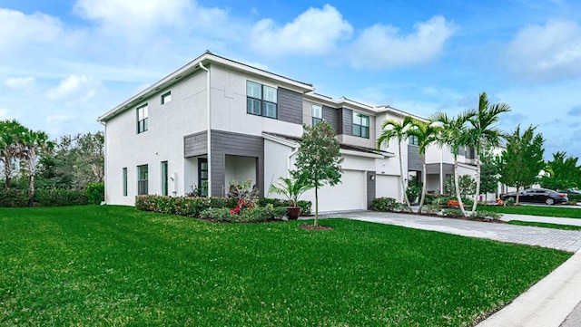 view of front of property with a garage, driveway, a front yard, and stucco siding