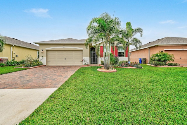 single story home featuring a front lawn, decorative driveway, an attached garage, and stucco siding