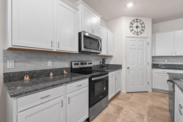 kitchen with dark stone counters, decorative backsplash, white cabinetry, and stainless steel appliances