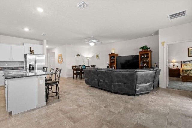 living area featuring ceiling fan, visible vents, and recessed lighting