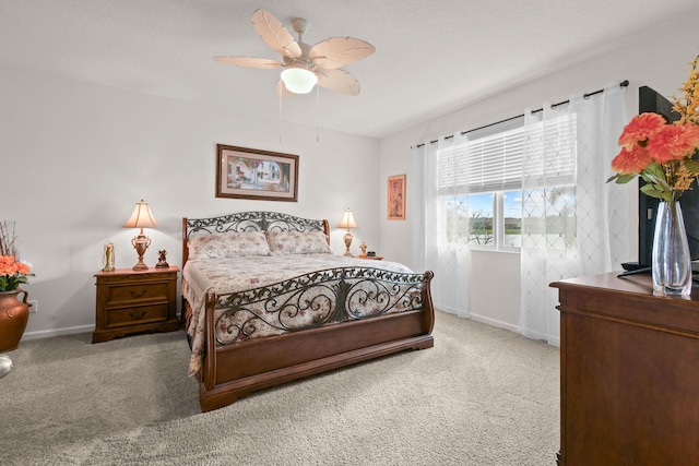 carpeted bedroom with a ceiling fan and baseboards