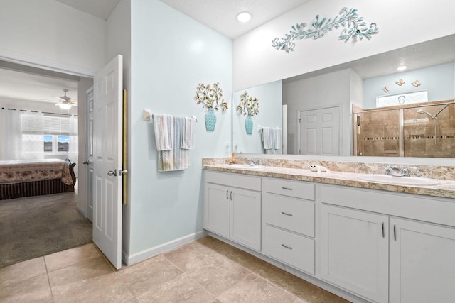 bathroom with connected bathroom, a shower stall, baseboards, and a sink