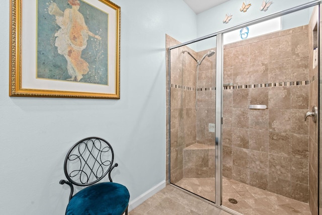 bathroom featuring a shower stall and baseboards