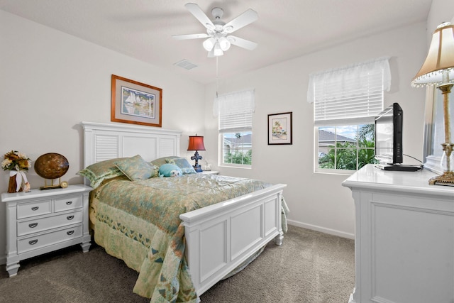 bedroom with dark carpet, visible vents, baseboards, and ceiling fan