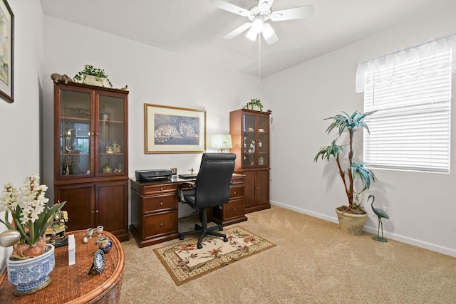 home office featuring baseboards, light colored carpet, and ceiling fan