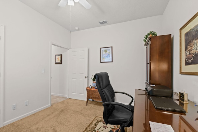 office area with baseboards, a ceiling fan, visible vents, and light colored carpet