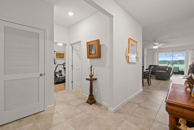 hallway featuring baseboards and light tile patterned floors