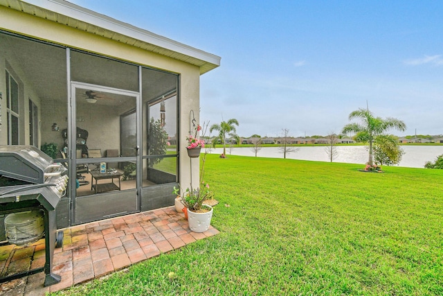view of yard with a sunroom and a water view