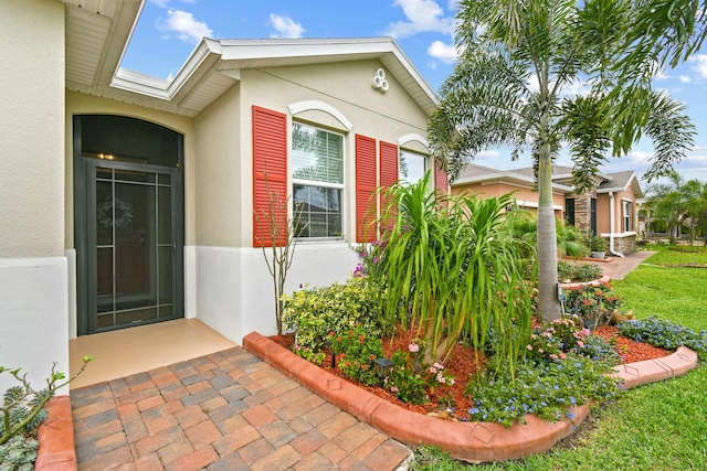 view of exterior entry with stucco siding