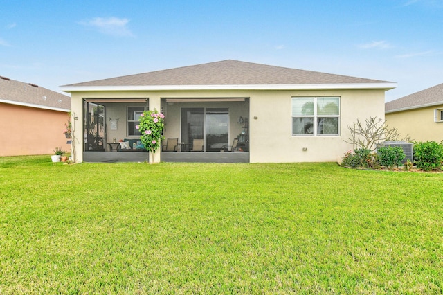 rear view of property with a sunroom, a yard, central AC, and stucco siding