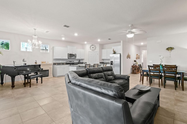 living room featuring light tile patterned flooring, visible vents, recessed lighting, and ceiling fan with notable chandelier