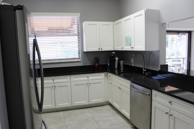 3371 Jog Park Dr, Greenacres, FL 33467 - kitchen featuring sink, light tile patterned floors, appliances with stainless steel finishes, white cabinets, and dark stone counters