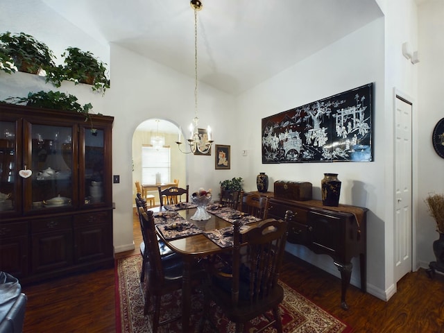 dining area featuring dark hardwood / wood-style flooring, a chandelier, and vaulted ceiling