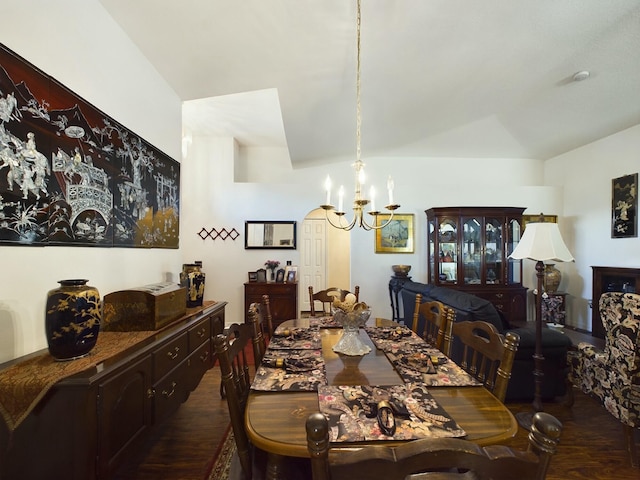 dining room with lofted ceiling, dark hardwood / wood-style flooring, and a chandelier