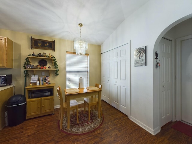 dining area featuring an inviting chandelier, lofted ceiling, and dark hardwood / wood-style floors