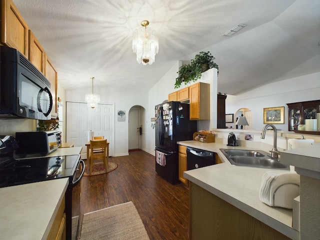 kitchen with pendant lighting, lofted ceiling, sink, dark hardwood / wood-style flooring, and black appliances