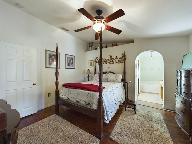 bedroom featuring ensuite bathroom, dark wood-type flooring, and ceiling fan