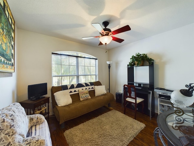 living room with ceiling fan and dark hardwood / wood-style flooring