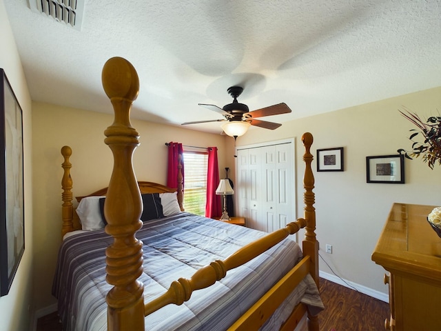 bedroom with ceiling fan, dark hardwood / wood-style flooring, a closet, and a textured ceiling