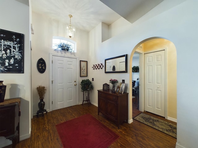 foyer entrance with a towering ceiling and dark hardwood / wood-style flooring