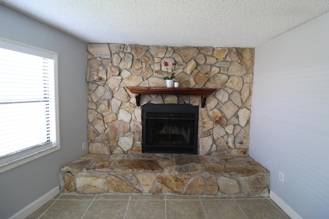 details with a stone fireplace, baseboards, and a textured ceiling