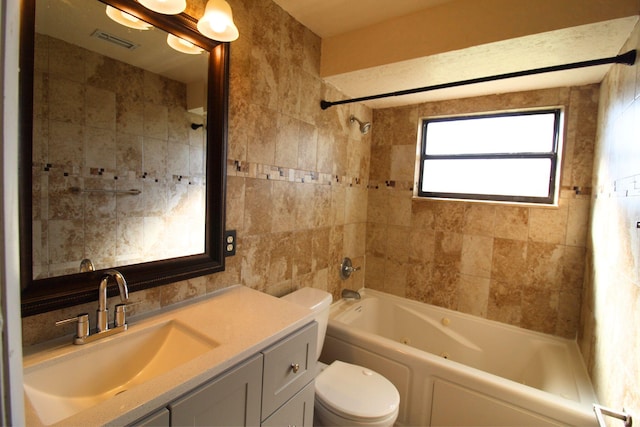 full bathroom featuring vanity, tile walls, toilet, tub / shower combination, and visible vents
