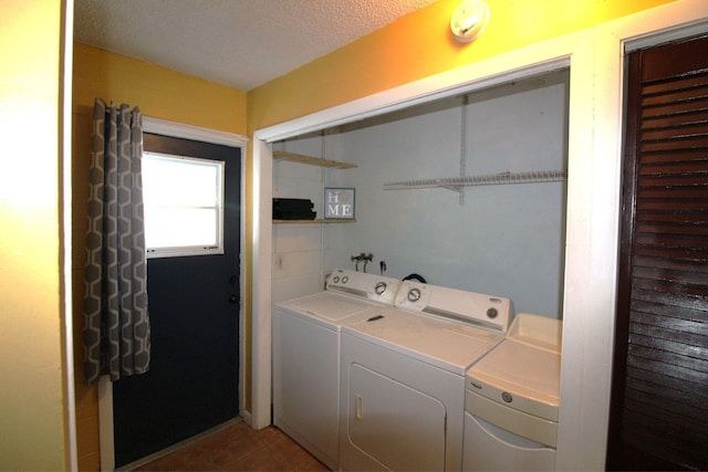 laundry room with laundry area, a textured ceiling, separate washer and dryer, and light tile patterned floors