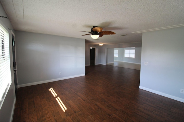 empty room with baseboards, wood finished floors, ceiling fan, and a textured ceiling