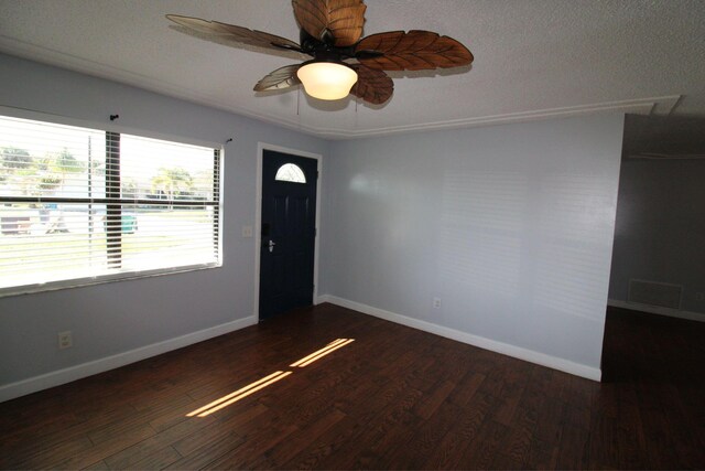 empty room with ceiling fan and a textured ceiling