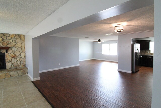 spare room featuring dark tile patterned flooring, a textured ceiling, and ceiling fan