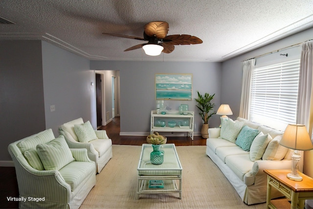 living area with a textured ceiling, visible vents, a ceiling fan, and wood finished floors