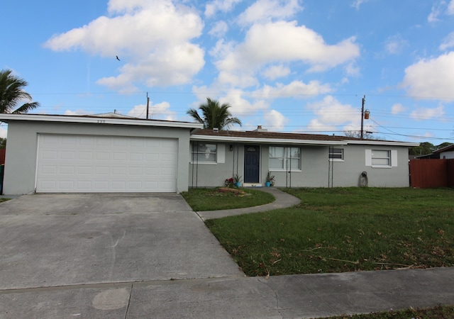 ranch-style house featuring a garage and a front lawn