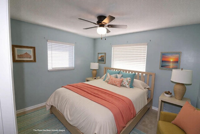 bedroom with baseboards, a ceiling fan, tile patterned flooring, and a textured ceiling
