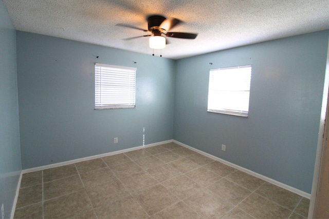unfurnished room featuring baseboards, a textured ceiling, ceiling fan, and light tile patterned floors