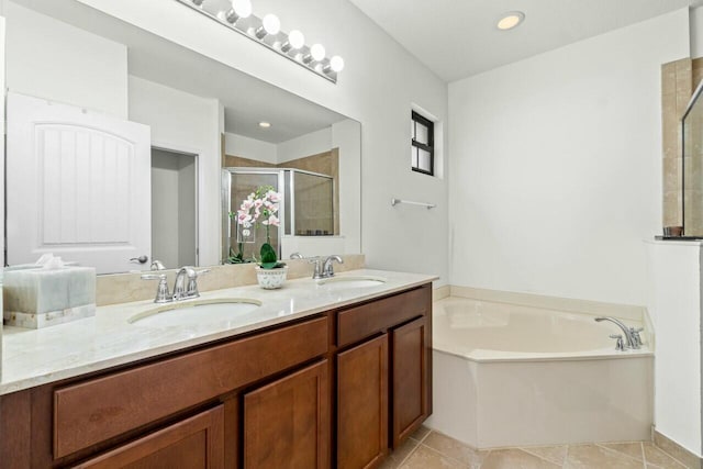 bathroom featuring a stall shower, a garden tub, a sink, and tile patterned floors