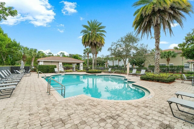 pool with fence and a patio