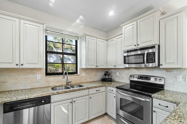 kitchen with white cabinetry, appliances with stainless steel finishes, decorative backsplash, and a sink