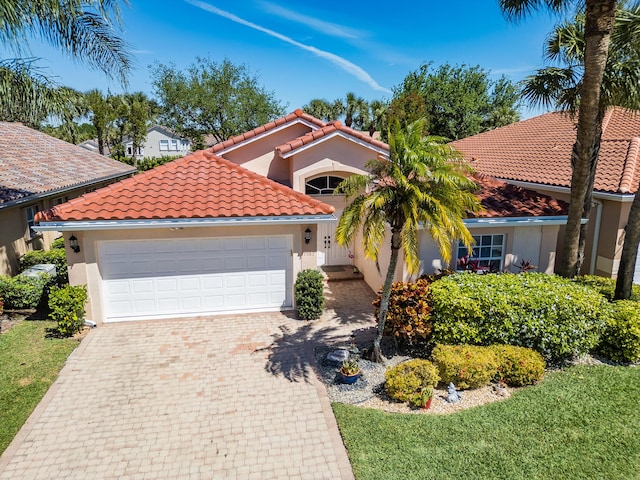 7087 Lombardy St, Boynton Beach, FL 33472 - mediterranean / spanish house featuring stucco siding, a tile roof, decorative driveway, and a garage