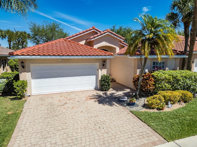 7087 Lombardy St, Boynton Beach, FL 33472 - mediterranean / spanish house with a tiled roof, decorative driveway, a garage, and stucco siding