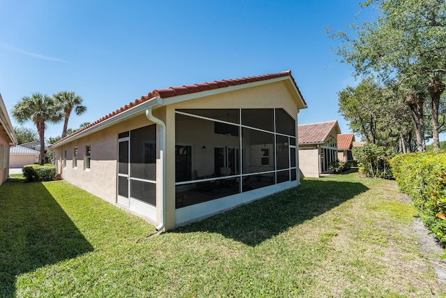 7087 Lombardy St, Boynton Beach, FL 33472 - rear view of house with a yard, a sunroom, stucco siding, and a tile roof