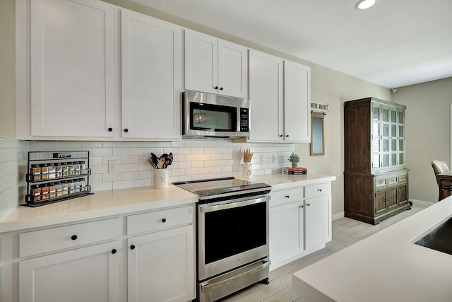 kitchen with appliances with stainless steel finishes, white cabinetry, and decorative backsplash